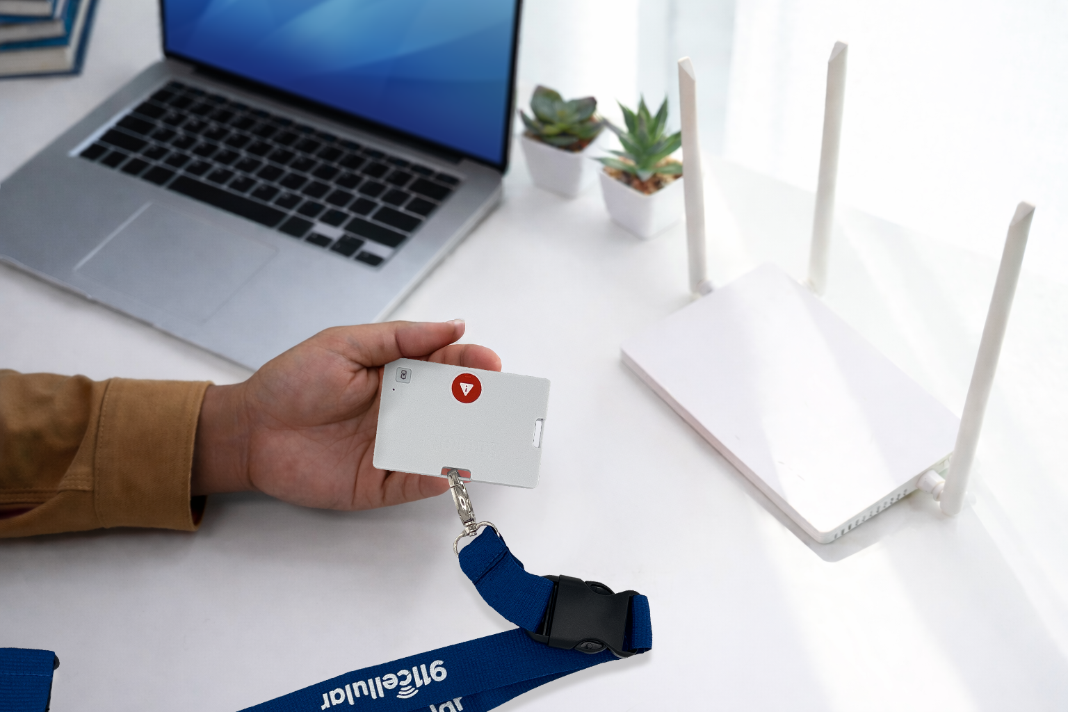 Man holding 911Cellular BadgeR+ near a modem